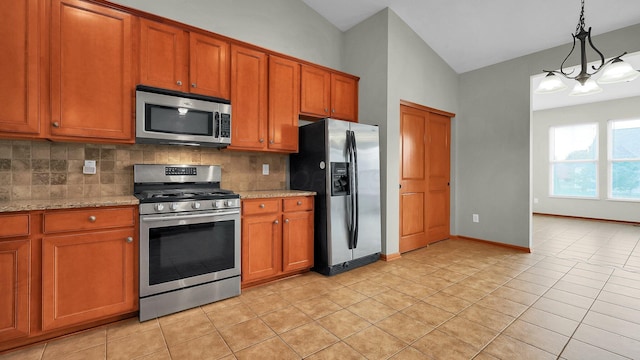 kitchen featuring light stone countertops, appliances with stainless steel finishes, backsplash, and vaulted ceiling