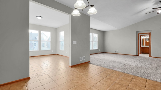 interior space with ceiling fan with notable chandelier, light colored carpet, and vaulted ceiling