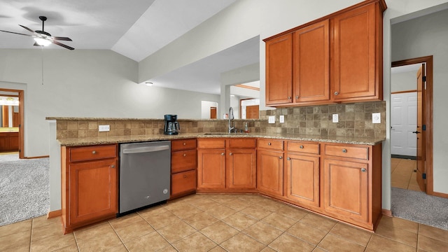 kitchen with dishwasher, light carpet, light stone counters, and sink