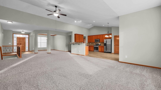 unfurnished living room featuring light colored carpet, vaulted ceiling, and ceiling fan