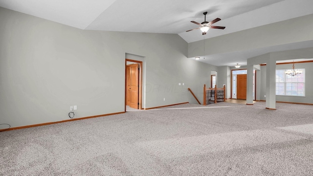 empty room featuring ceiling fan with notable chandelier, carpet floors, and vaulted ceiling