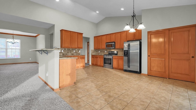 kitchen featuring kitchen peninsula, appliances with stainless steel finishes, a kitchen bar, light colored carpet, and an inviting chandelier