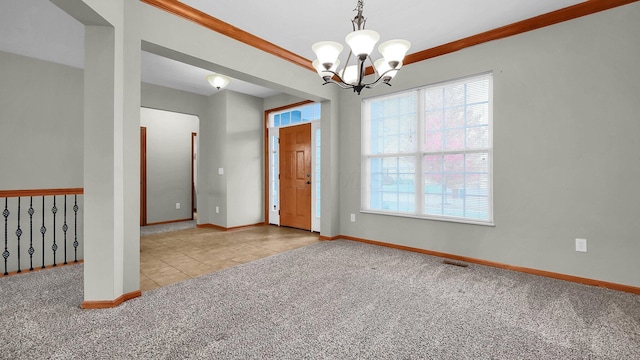 spare room featuring ornamental molding, light carpet, and an inviting chandelier