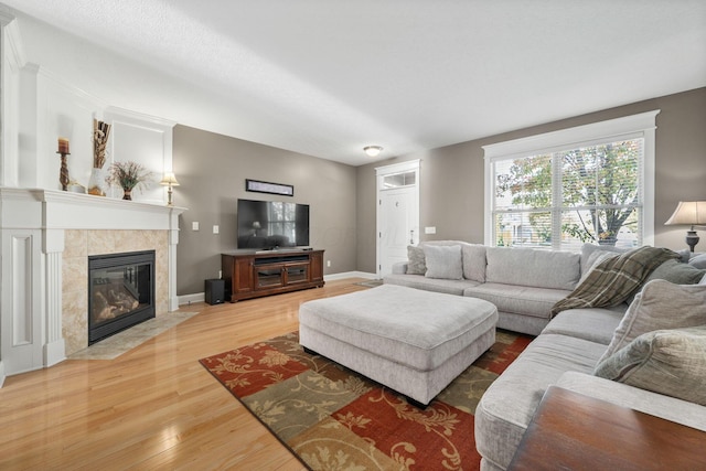 living room featuring a tiled fireplace and hardwood / wood-style floors