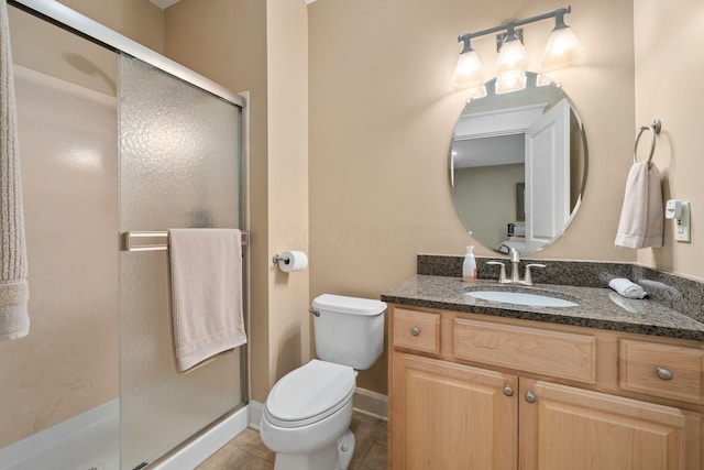 bathroom featuring tile patterned floors, vanity, toilet, and walk in shower