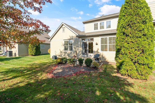 rear view of property with a lawn and central AC