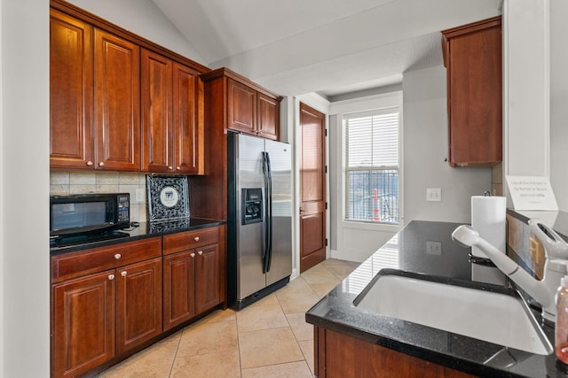 kitchen featuring stainless steel refrigerator with ice dispenser, tasteful backsplash, sink, light tile patterned floors, and lofted ceiling