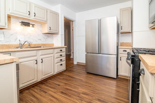 kitchen with dark wood-type flooring, white cabinets, sink, tasteful backsplash, and stainless steel appliances