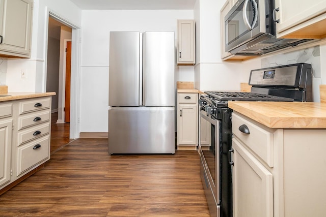 kitchen with dark hardwood / wood-style flooring, butcher block counters, stainless steel appliances, and tasteful backsplash