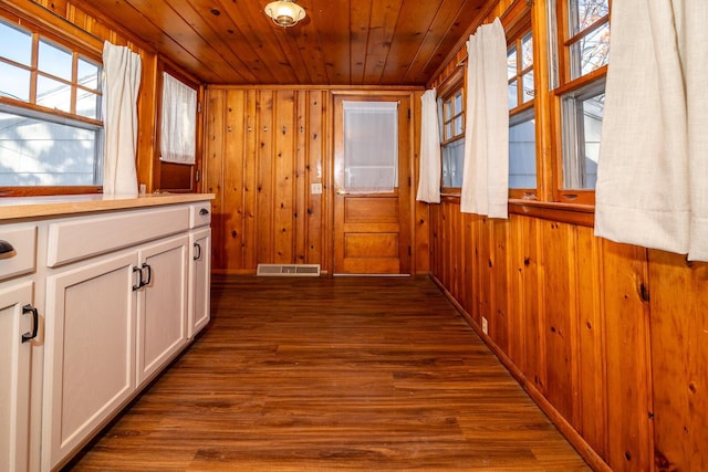 hallway featuring wooden ceiling, dark wood-type flooring, and wooden walls