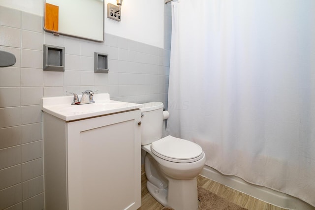 full bathroom with vanity, toilet, shower / bath combo with shower curtain, tile walls, and wood-type flooring