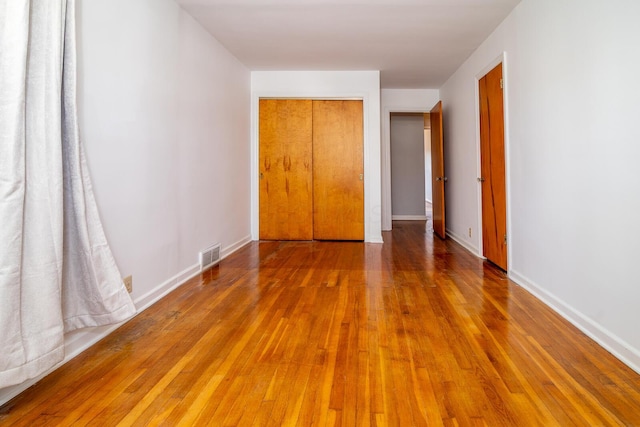 unfurnished bedroom featuring hardwood / wood-style flooring and a closet