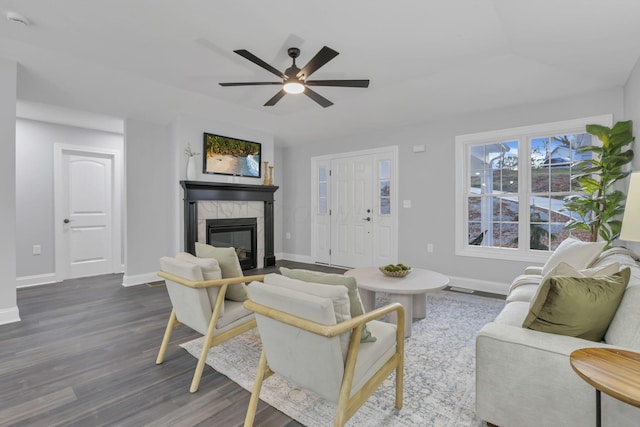 living room featuring a tile fireplace, dark hardwood / wood-style flooring, and ceiling fan