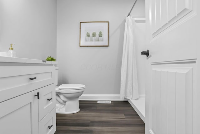 bathroom featuring a shower with shower curtain, vanity, hardwood / wood-style flooring, and toilet