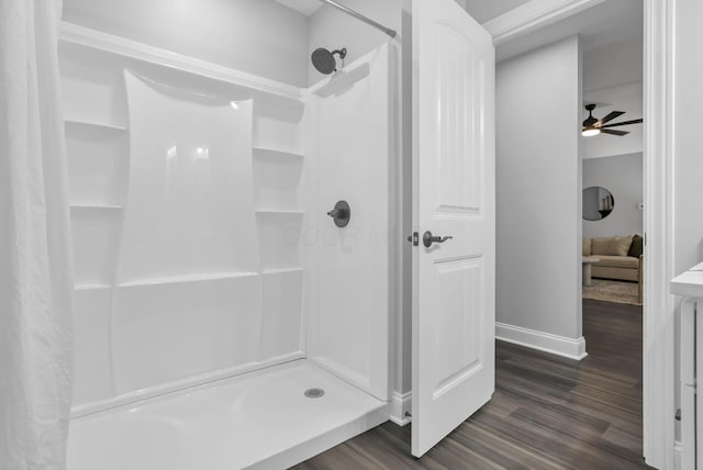 bathroom with hardwood / wood-style floors, a shower with curtain, and ceiling fan