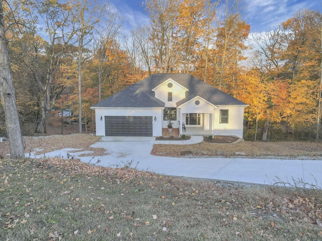 view of front of house with a front lawn, covered porch, and a garage