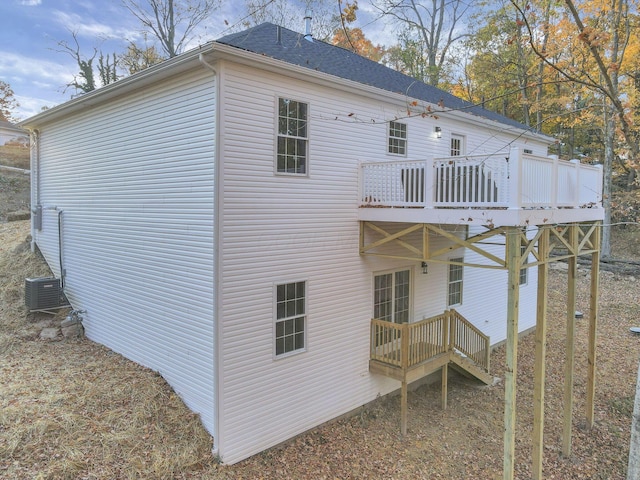 rear view of house with central AC and a wooden deck