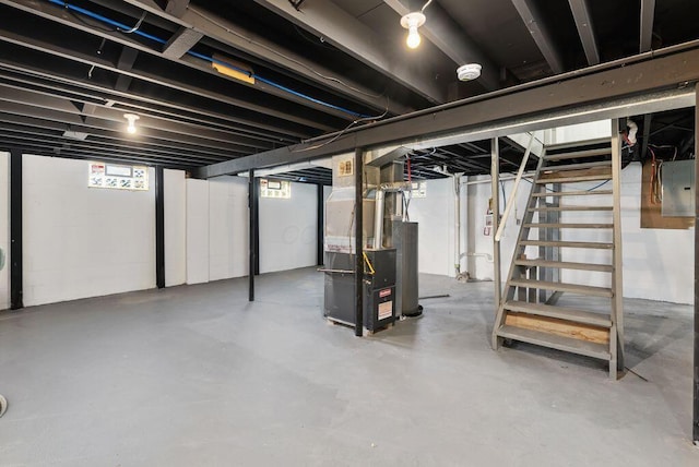 basement with gas water heater, electric panel, and heating unit