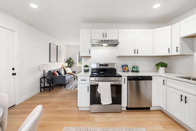 kitchen featuring white cabinets, appliances with stainless steel finishes, and light wood-type flooring