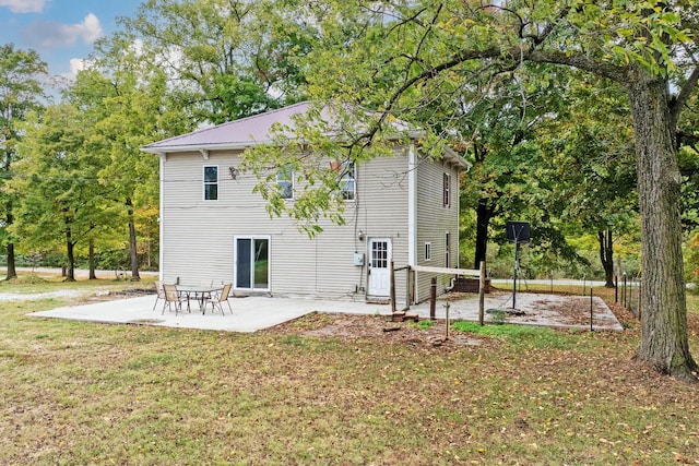 back of house with a lawn and a patio