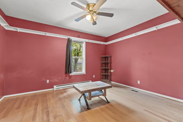 interior space with baseboard heating, ceiling fan, and wood-type flooring