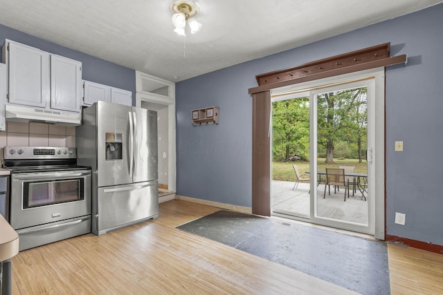 kitchen with white cabinets, stainless steel appliances, and light hardwood / wood-style flooring