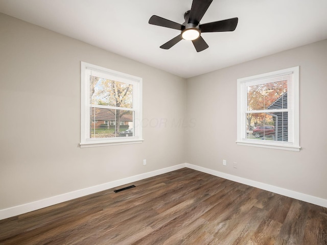 unfurnished room with ceiling fan, a healthy amount of sunlight, and dark hardwood / wood-style flooring