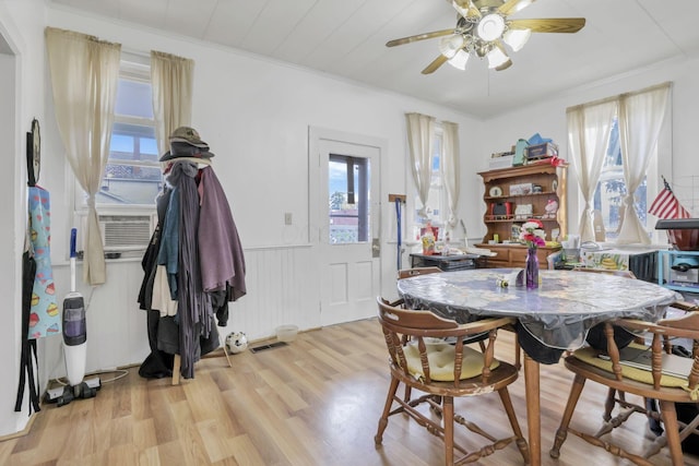 622 S Poplar St, Bucyrus, OH 44820 - dining area with light wood-style floors, ceiling fan, wainscoting, and cooling unit