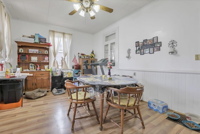 dining space with ceiling fan, wainscoting, and light wood-style floors