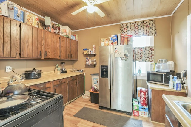 kitchen featuring crown molding, light wood finished floors, stainless steel appliances, light countertops, and wood ceiling