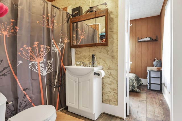 bathroom featuring toilet, wood finished floors, and vanity