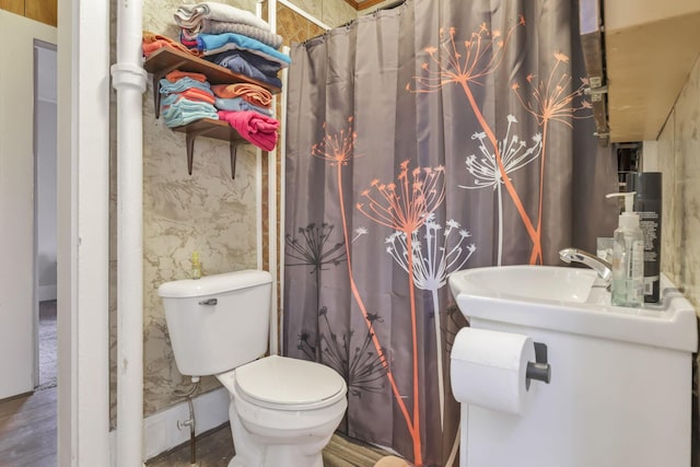 bathroom featuring curtained shower, toilet, and wallpapered walls