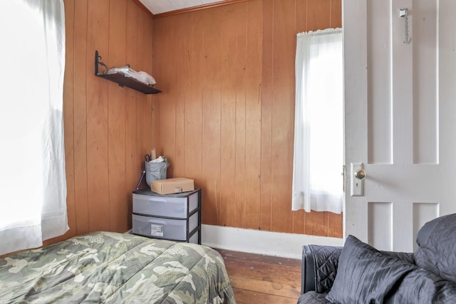 bedroom with wood walls and wood finished floors