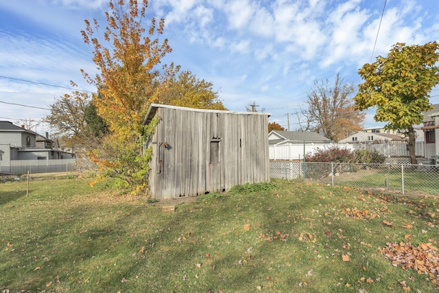 view of yard featuring an outbuilding, fence, and a storage shed