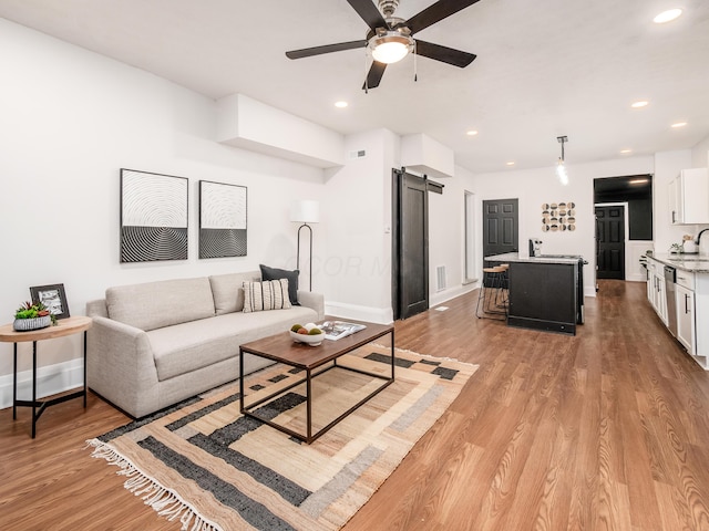 1327 Atcheson St, Columbus, OH 43203 - living area featuring a barn door, light wood finished floors, ceiling fan, and recessed lighting