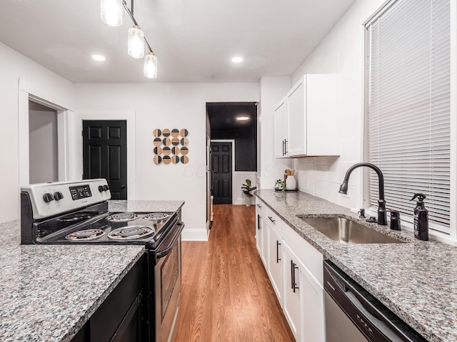 1327 Atcheson St, Columbus, OH 43203 - kitchen featuring appliances with stainless steel finishes, light wood-type flooring, white cabinetry, light stone counters, and recessed lighting