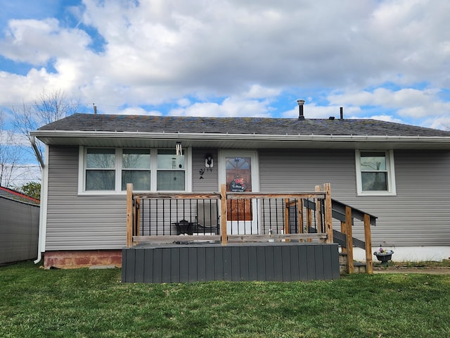 rear view of house featuring a deck and a lawn