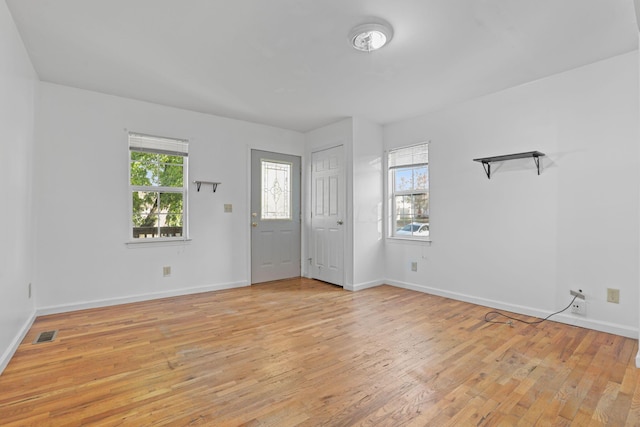 foyer entrance with light hardwood / wood-style floors and a healthy amount of sunlight