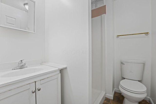 bathroom with vanity, toilet, and walk in shower