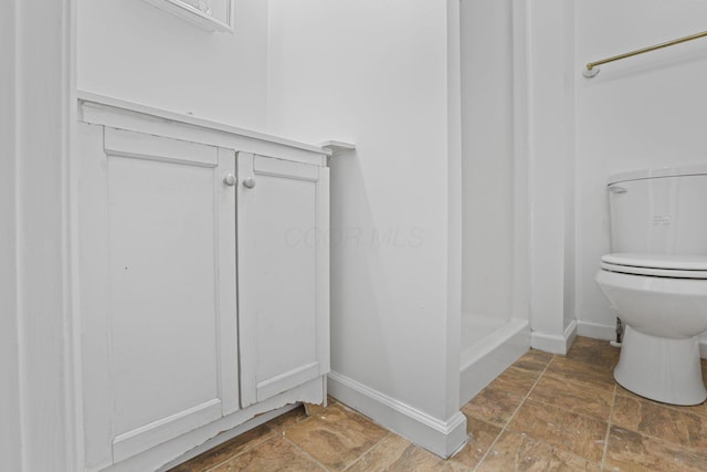 bathroom featuring toilet and walk in shower