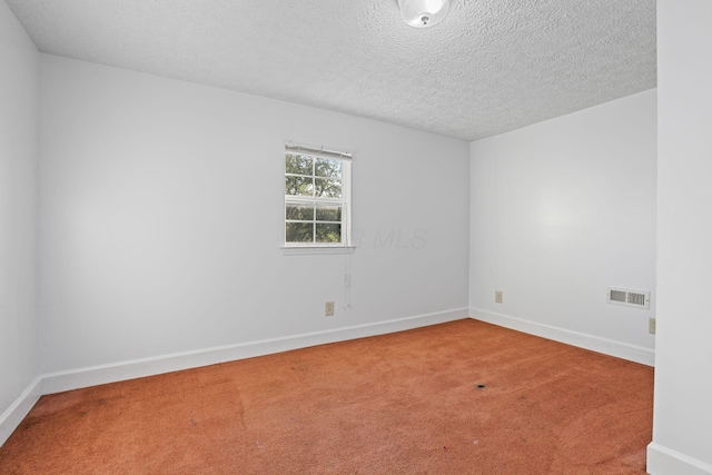 carpeted empty room featuring a textured ceiling