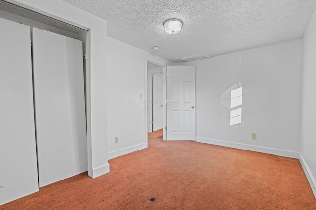 unfurnished bedroom featuring light colored carpet and a textured ceiling