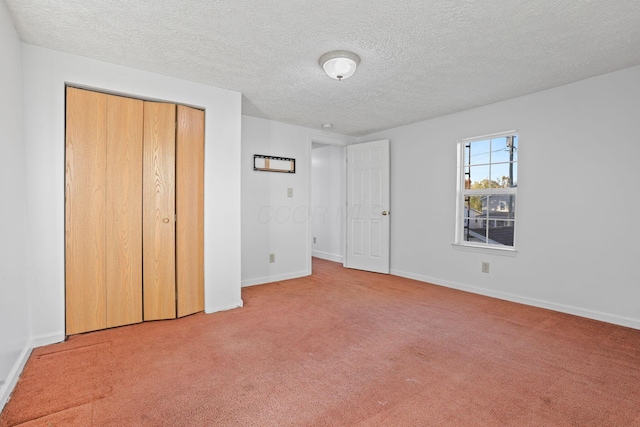 unfurnished bedroom featuring light carpet, a closet, and a textured ceiling