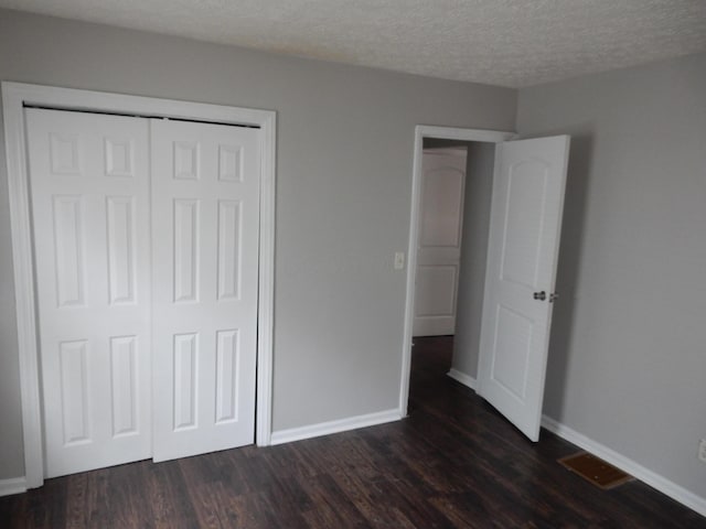 1447 Republic Ave, Columbus, OH 43211 - unfurnished bedroom featuring a textured ceiling, a closet, and dark wood-type flooring