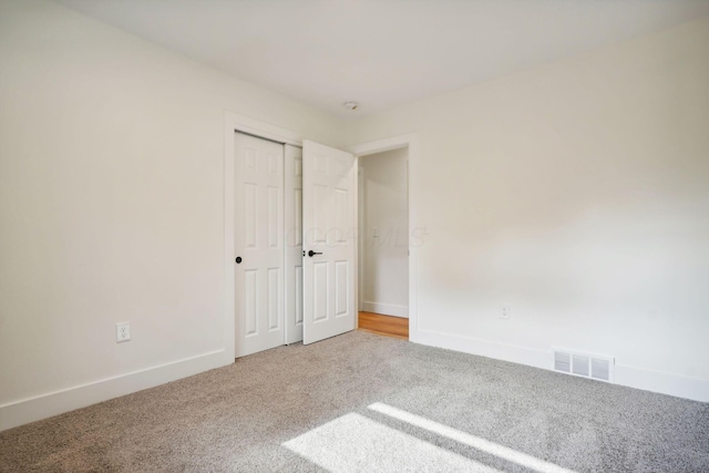 unfurnished bedroom with carpet flooring and a closet