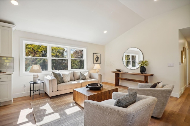 living room with light hardwood / wood-style floors and lofted ceiling