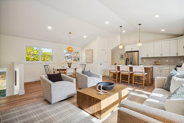 living room featuring light hardwood / wood-style floors and vaulted ceiling