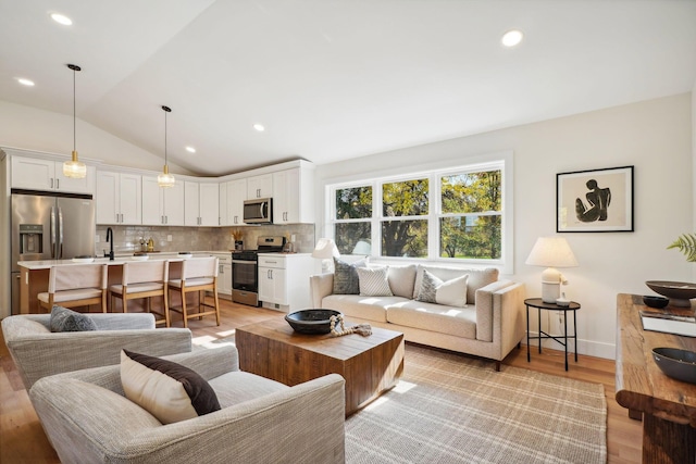 living room featuring light hardwood / wood-style floors and lofted ceiling