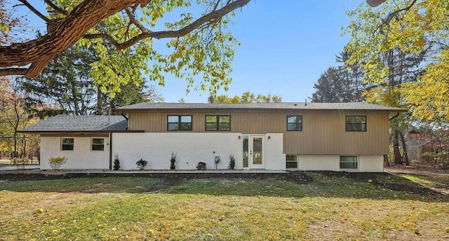 rear view of property featuring a lawn