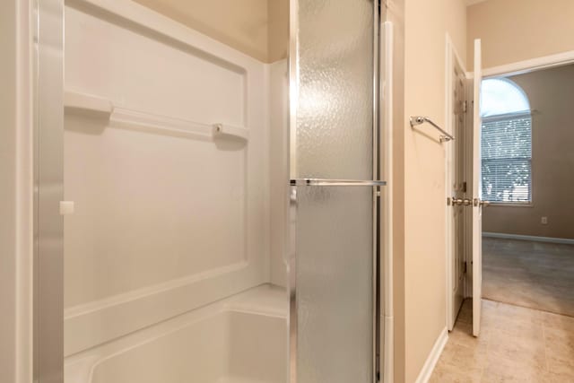 bathroom with a shower with door